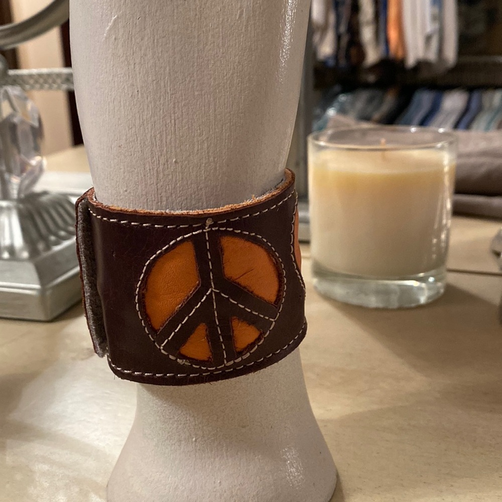 Leather peace and love snap bracelet with hidden zipper pocket.